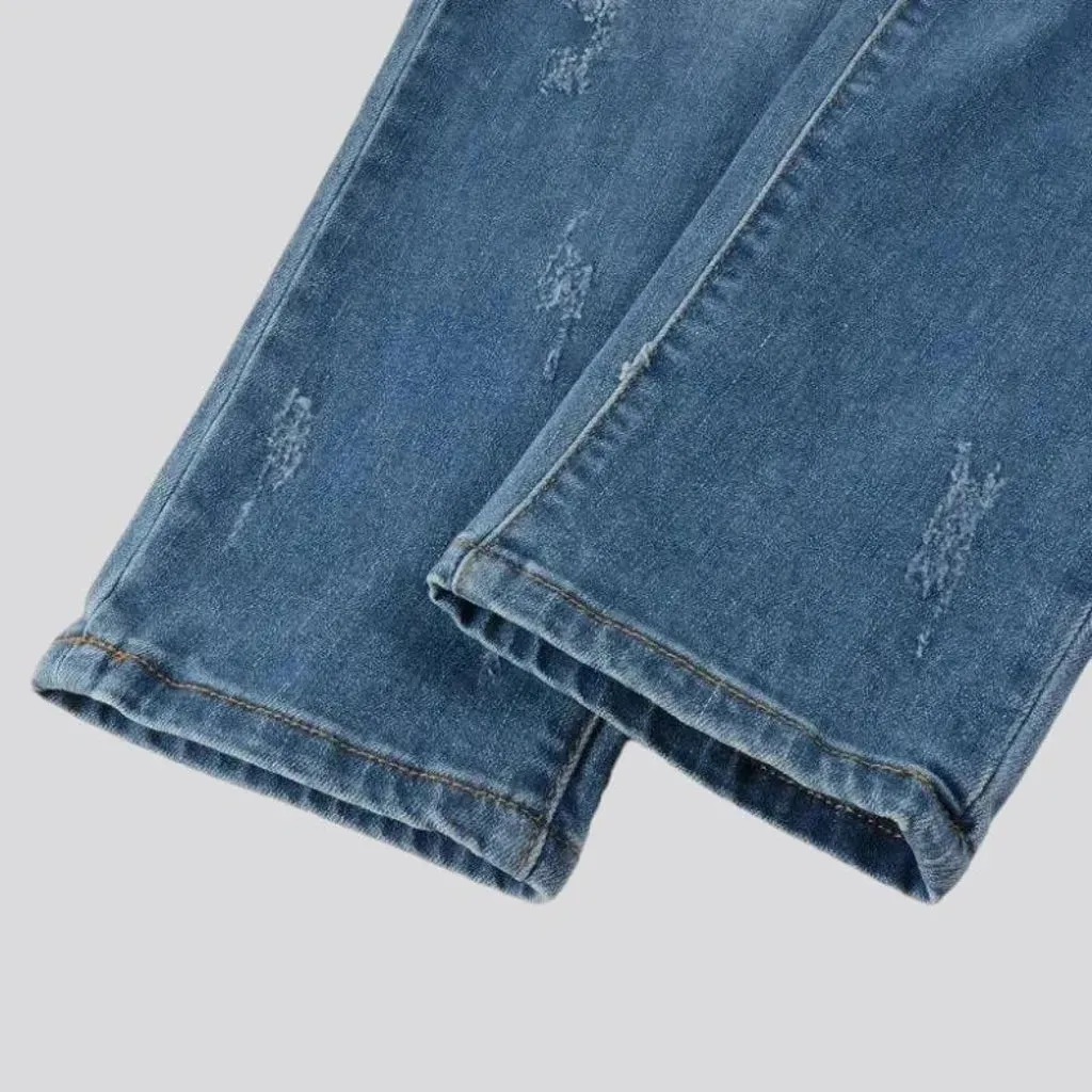 Damaged men's whiskered jeans