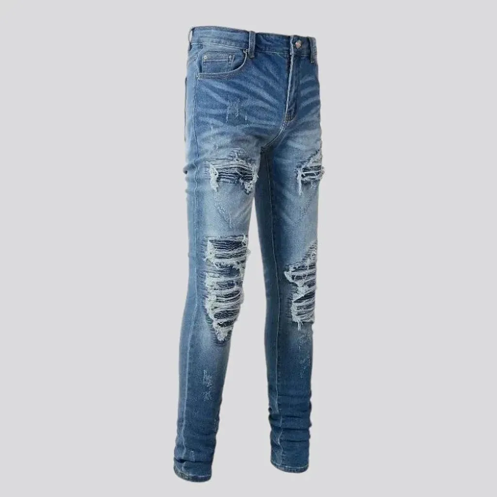 Damaged men's whiskered jeans